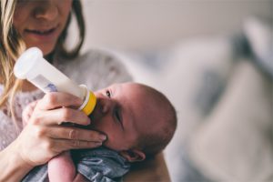 Parent feeding baby with a bottle
