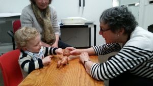 Adult and child playing with doll